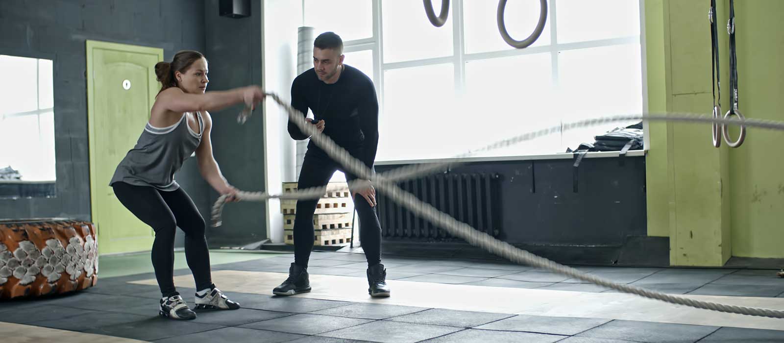 female athlete training on battle ropes
